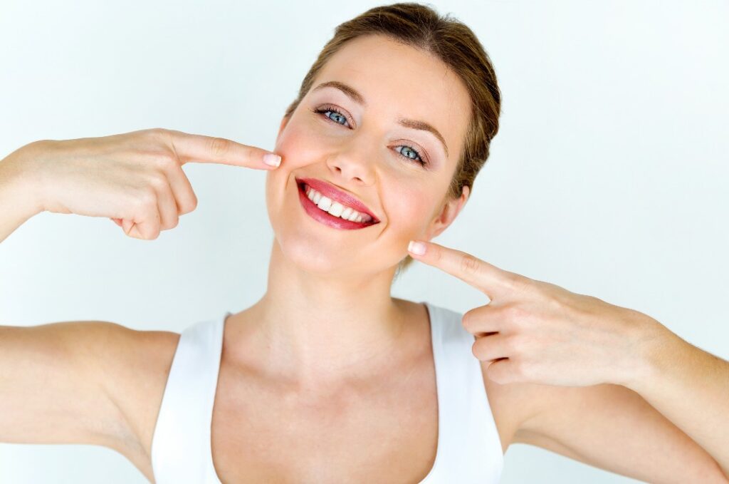 Schöne junge Frau mit einem perfekten Lächeln nach dem Zähnebleachen